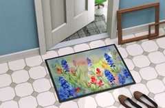 Decorative doormat with floral design on a tiled floor next to a door.