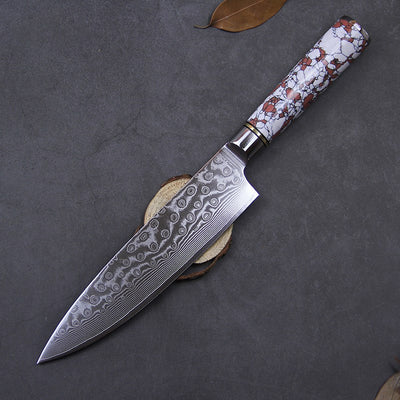 Decorative knife with a patterned handle on a dark surface