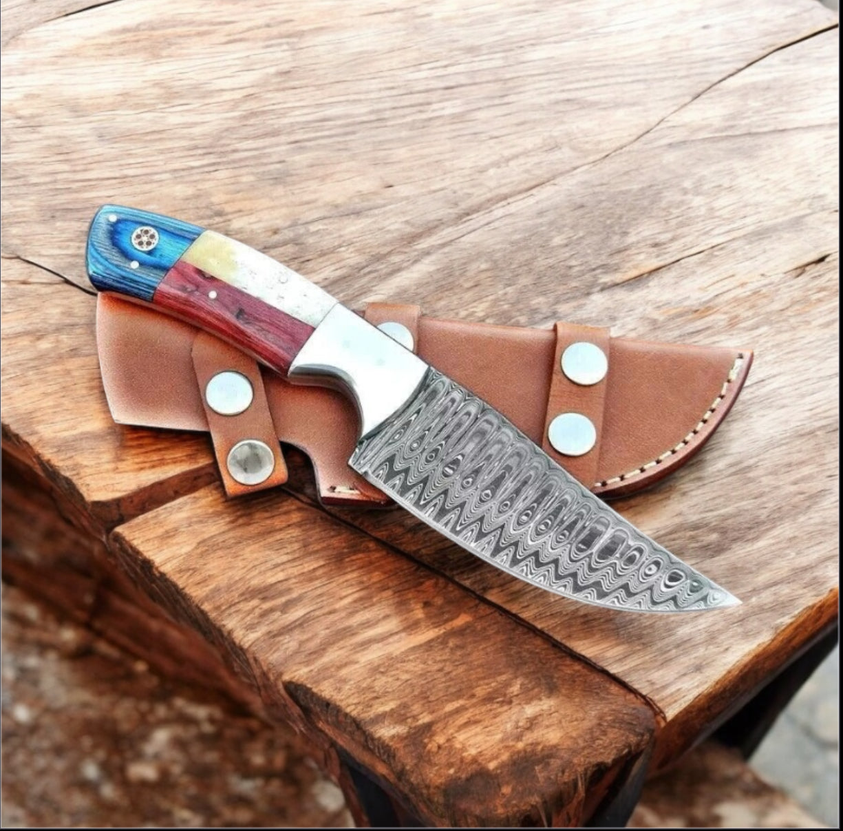 Decorative knife with a patterned blade in a leather sheath. 