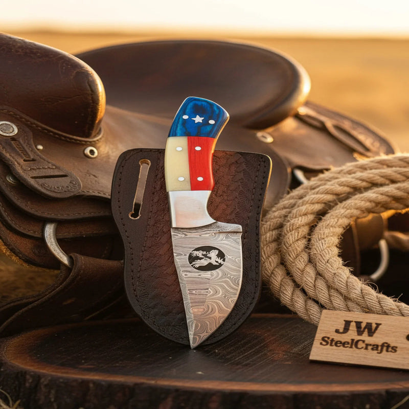 Knife with American flag handle on a wooden surface with leather and rope
