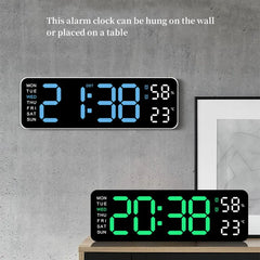 Digital alarm clock with blue and green LED display on a gray wall.