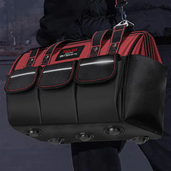 Black and red tool bag with visible brand logo held by a person against a dark background