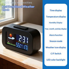 A black multifunctional digital weather clock sitting on a wooden windowsill, showing a colorful weather icon display on its screen. The image includes text overlays describing the clock's features on the left and a blue panel on the right listing features like time display, temperature display, humidity display, alarm function, snooze mode, weather icon display, C/F Switch, and LED color backlight.