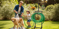 Man and child with a dog using a hose in a garden, with a hose reel stand in the background.