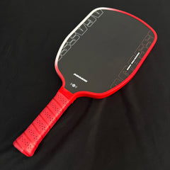 Red and black pickleball paddle on a black background