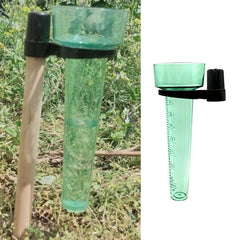 Green plastic bird feeder with black holder on a grassy background