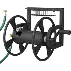 Black metal outdoor hose reel with a hand crank, wall-mounted bracket, and attached black wire hose holder, shown with a green garden hose on a white background.
