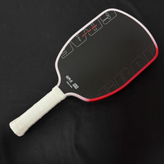 Pickleball paddle with black surface and white handle on a black background