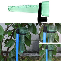 Green rain gauge with blue stand and black caps on a leafy background