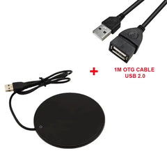 Black circular charging pad with USB cable and OTG adapter on a white background