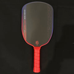 A pickleball paddle with a dark gray/black textured blade, red trim, and a red wrapped handle, shown against a black background.