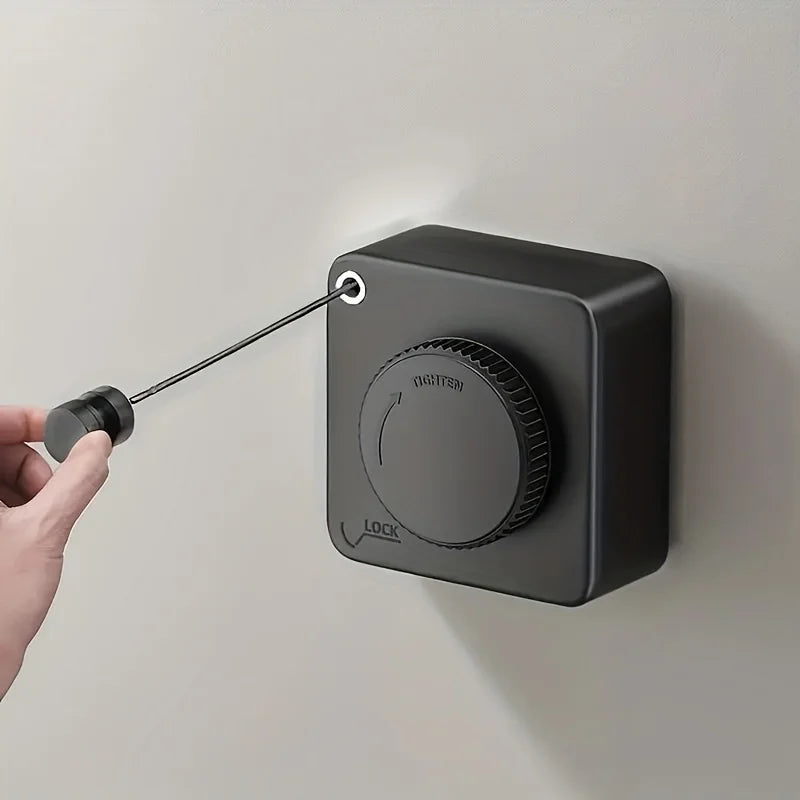 Black wall-mounted lock with a hand using a key to unlock it on a light gray background