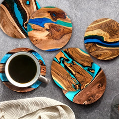 Wooden coasters with blue and brown resin design on a gray surface with a cup of coffee.