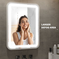 Woman applying skincare product in front of a large illuminated mirror with text 'Larger Defog Area'.
