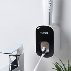 Black and white toothbrush holder with 'ecoco' branding on a white wall.