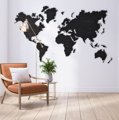 World map wall decoration in a room with a chair and plant.