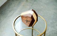 Wooden clock with gold accents on a glass table
