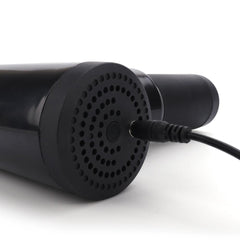 Black cylindrical device with a textured surface and power cord on a white background